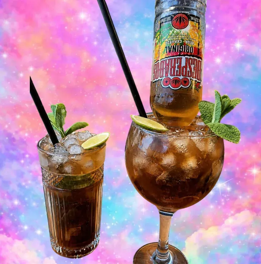 Dos cócteles helados con menta y lima, uno en un vaso alto y otro en una copa con tallo, sobre un fondo rosa.