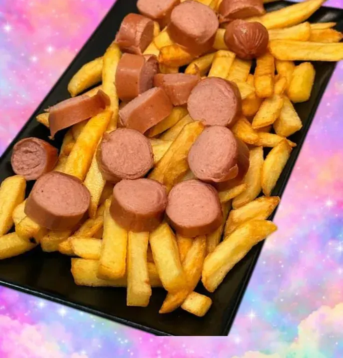 Bandeja negra de patatas fritas con salchicha en rodajas sobre un fondo rosa-púrpura.