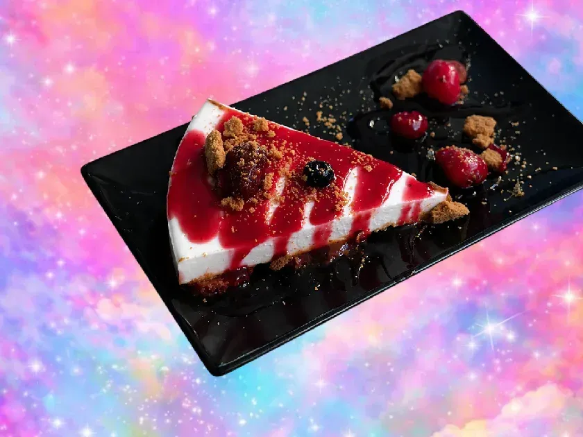Porción de tarta de queso con fresas en un plato negro con fresas y cobertura de migas sobre un fondo rosa brillante.