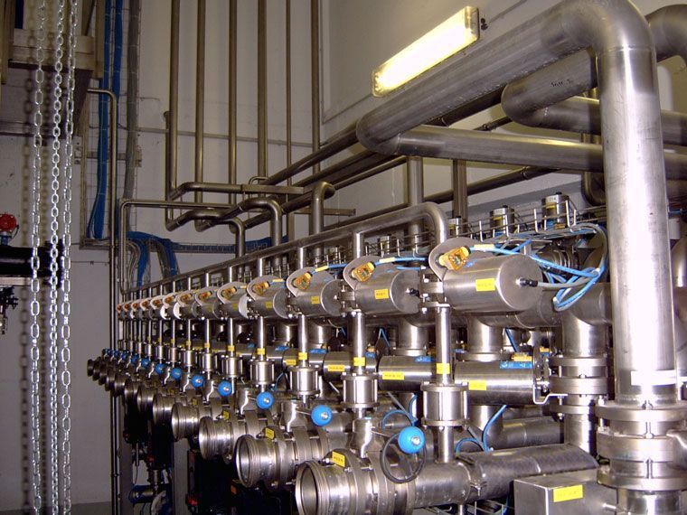 Industrielle Rohrleitungen und Ventile aus Edelstahl in einer Verarbeitungsanlage.