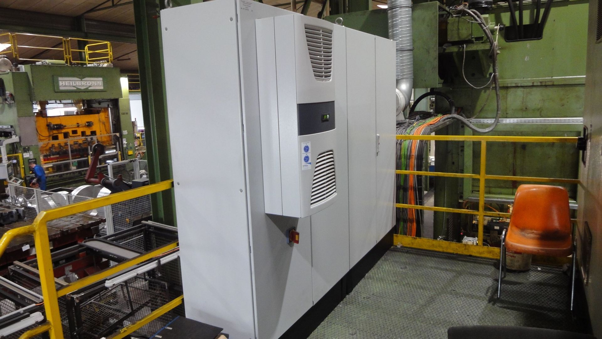 Großer grauer Industrie-Steuerschrank in einer Fabrikumgebung.