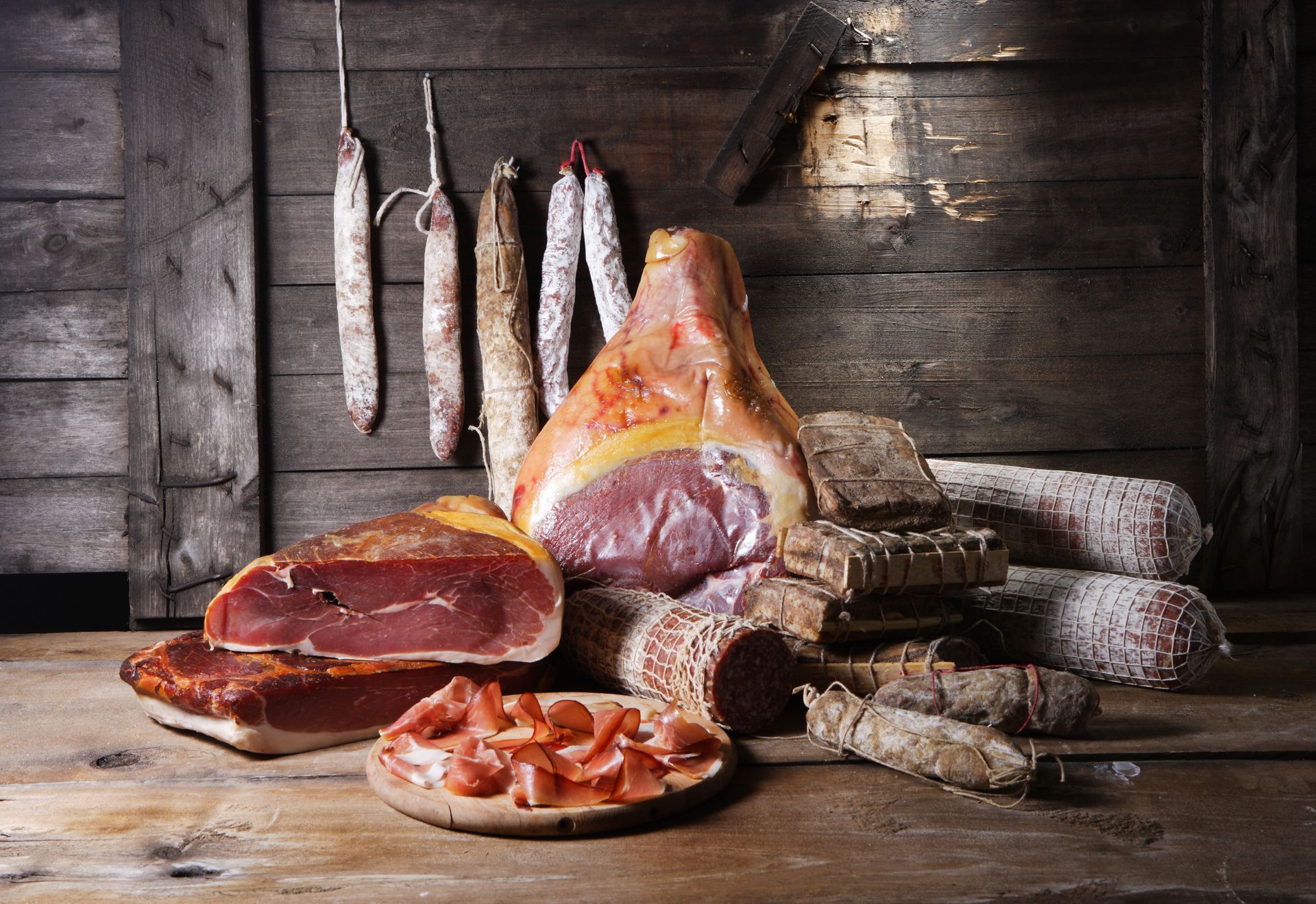 Des jambons et saucisses suspendus.