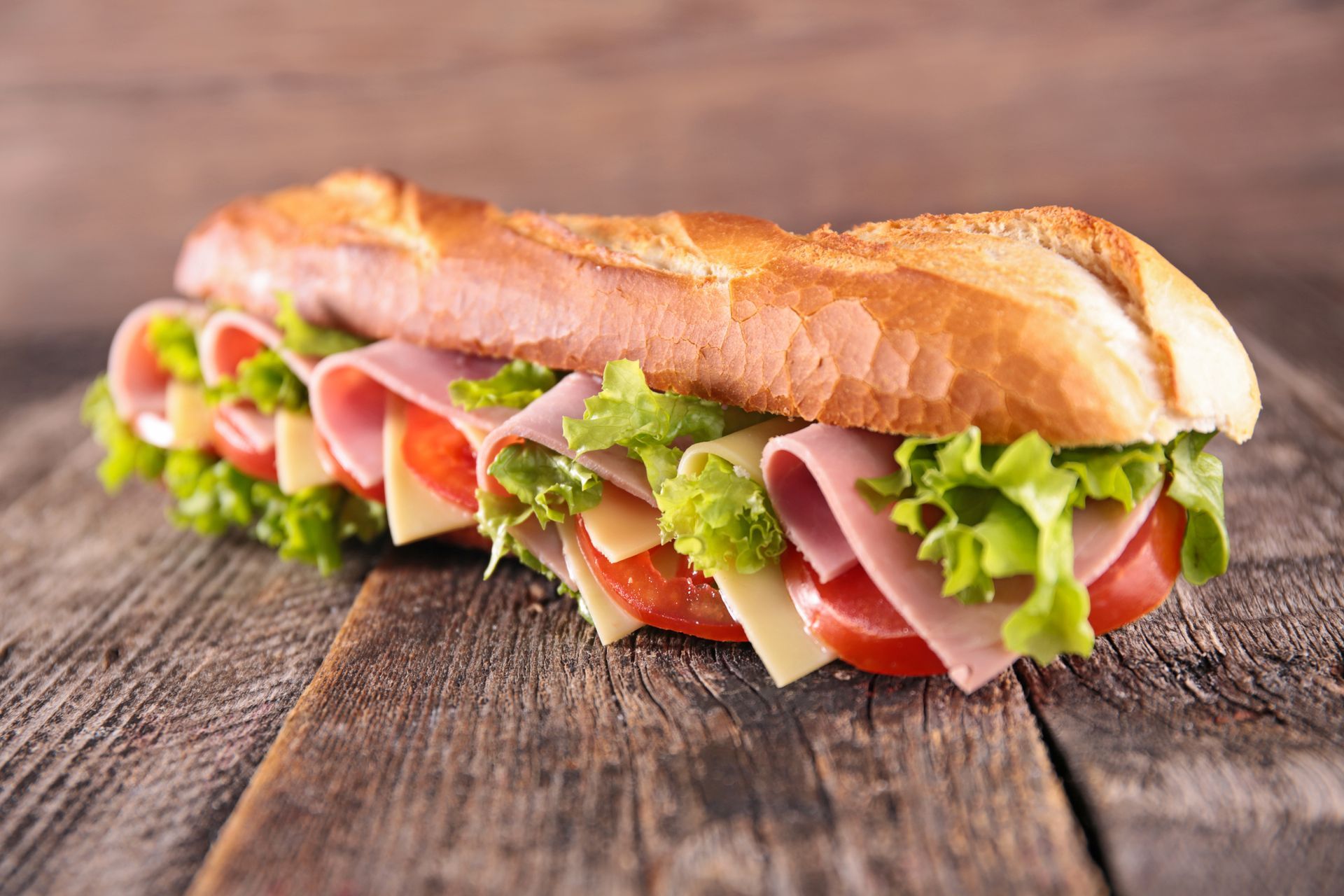 Un sandwich avec du jambon et des crudités.