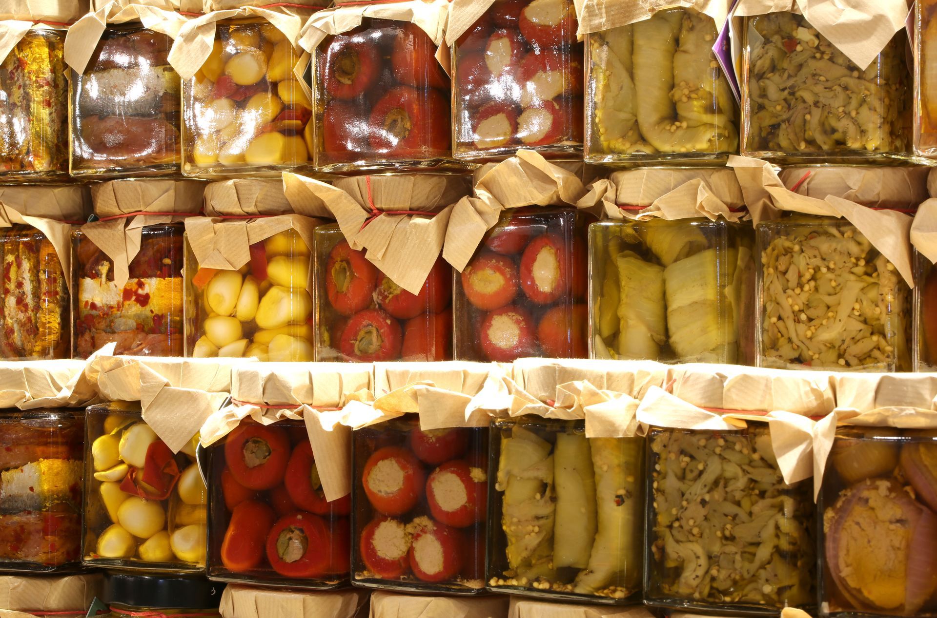 Plusieurs bocaux de conserves remplis de légumes marinés.