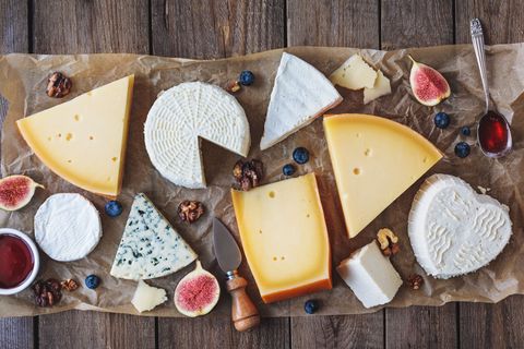 Une planche de fromages variés avec des fruits.