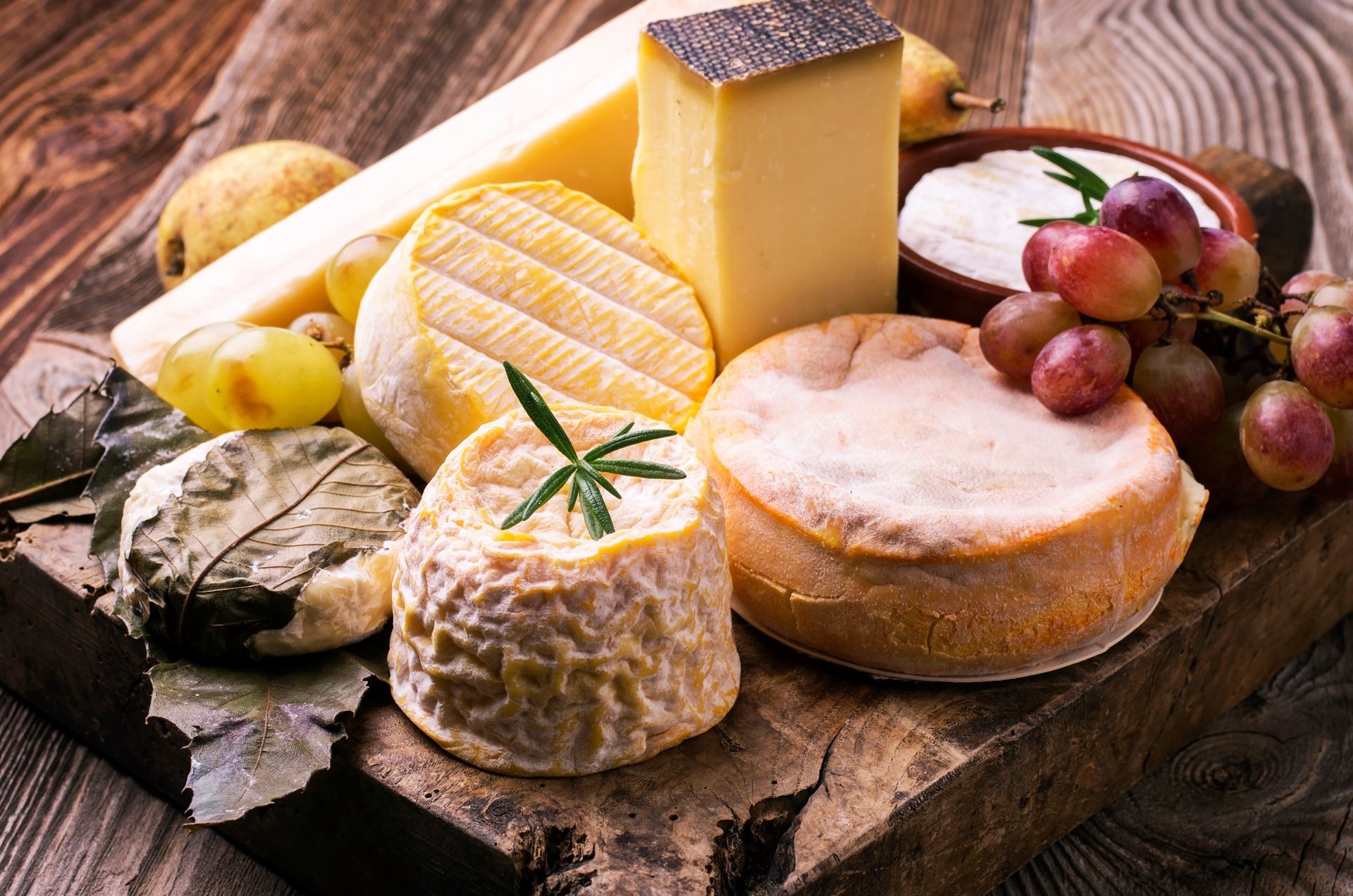 Une planche de fromages avec des raisins.