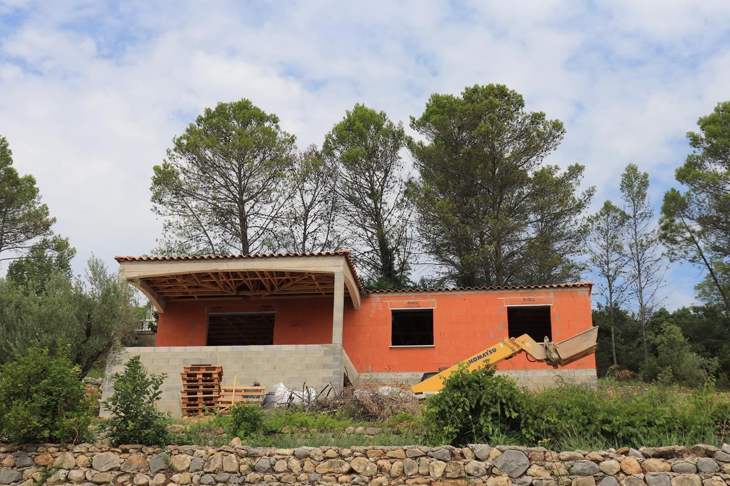 Une maison en cours de construction avec une terrasse couverte