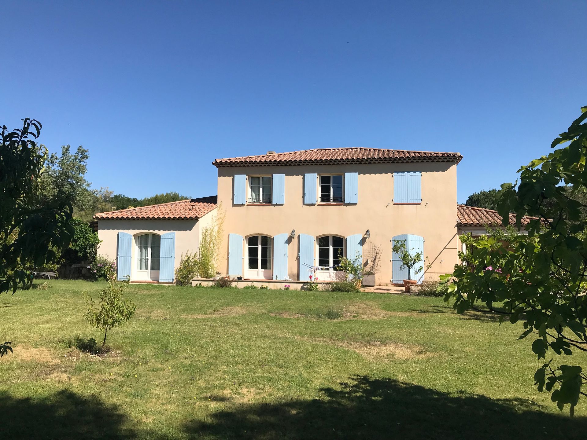 Une maison de style provençal avec des volets bleus