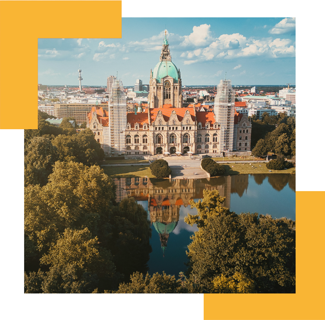 Historisches Gebäude mit einer grünen Kuppel, die sich in einem Teich spiegelt, eingerahmt von Bäumen