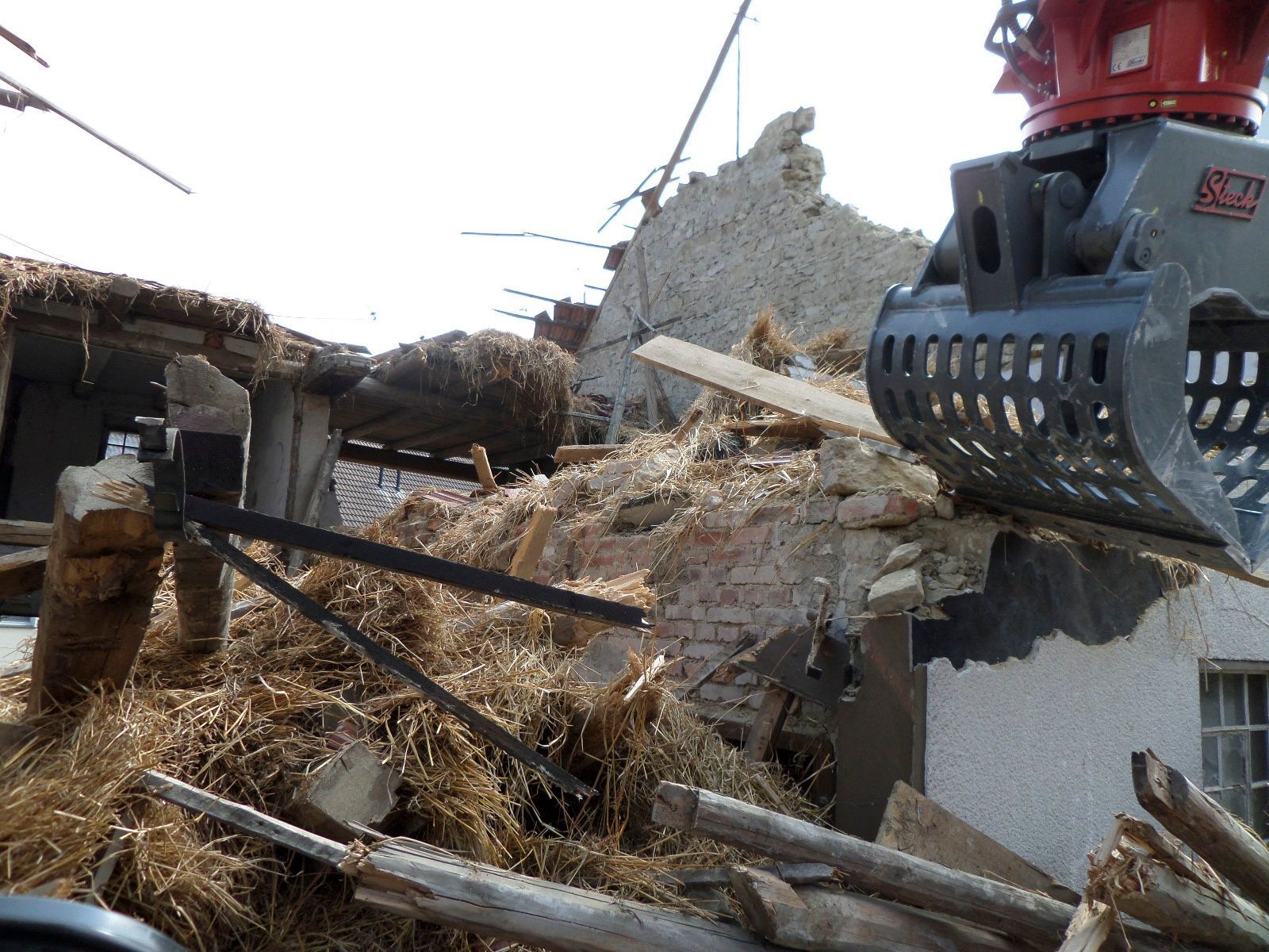 Ein Kran reißt ein Gebäude mit viel Schutt ab