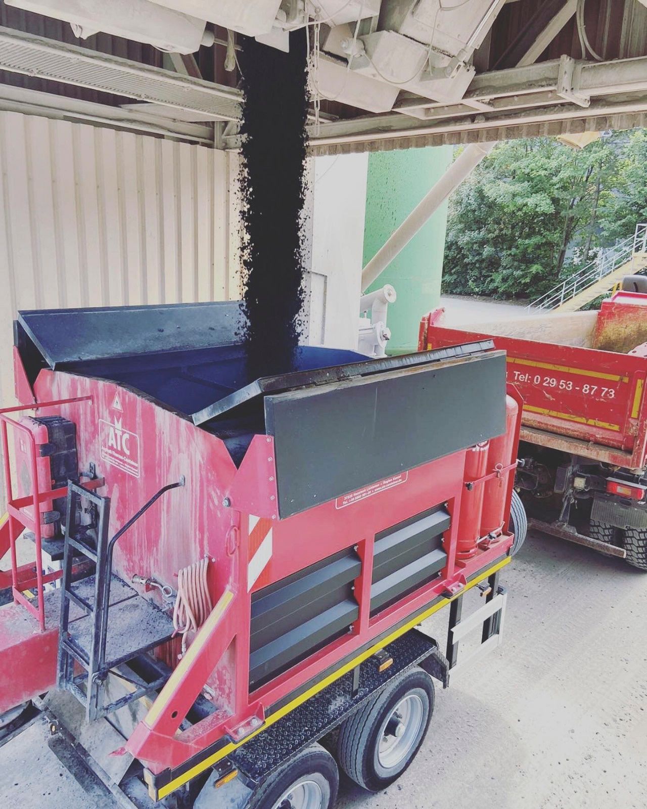 Ein roter LKW wird mit Schwarzpulver beladen.