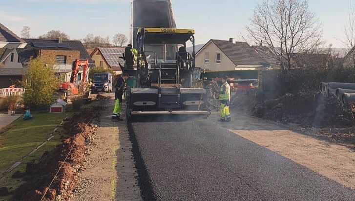 Eine Gruppe von Leuten arbeitet an einer Straße.