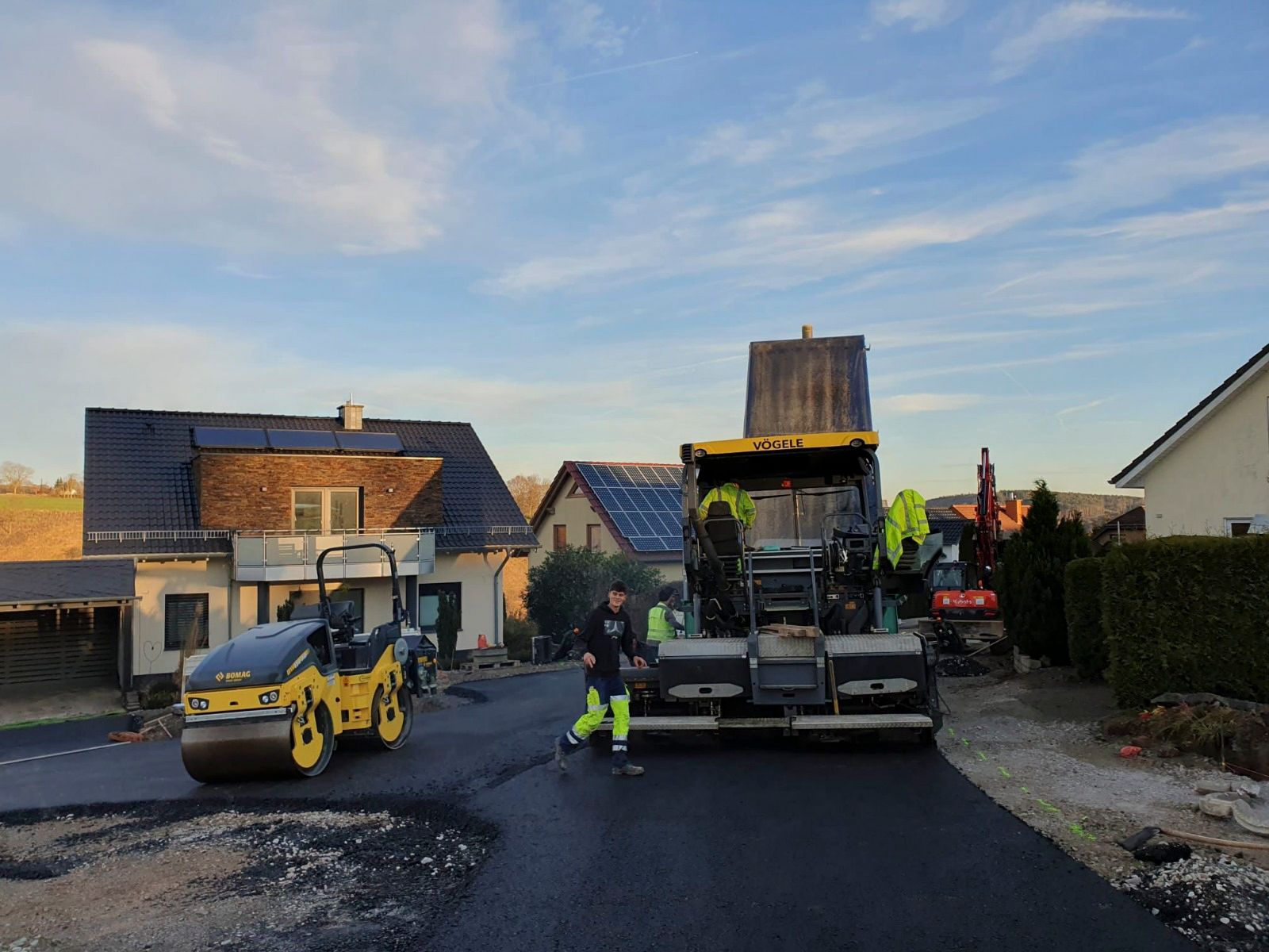 Am Straßenrand parken einige Baufahrzeuge.