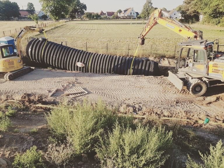 Ein gelber Bagger gräbt ein Loch in den Boden