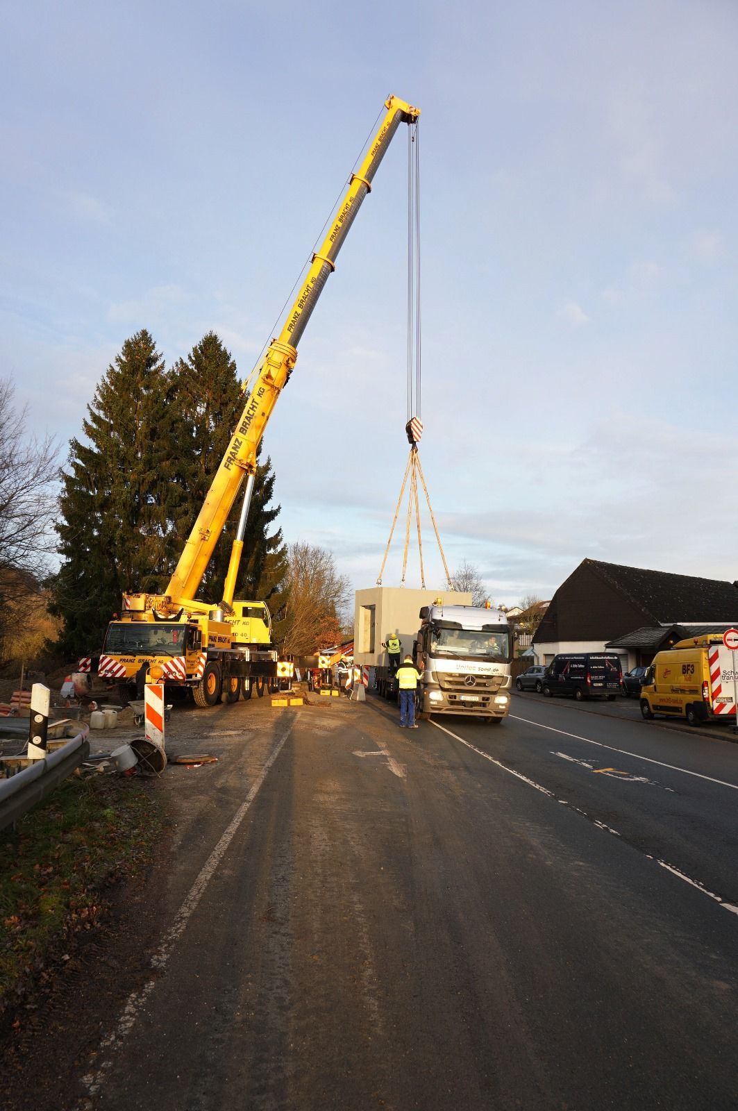 Ein LKW wird von einem Kran am Straßenrand angehoben