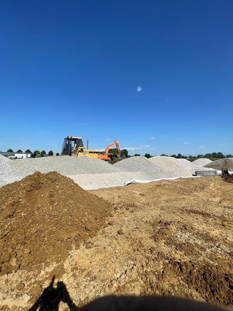 Eine Planierraupe fährt durch einen Erdhaufen auf einer Baustelle.