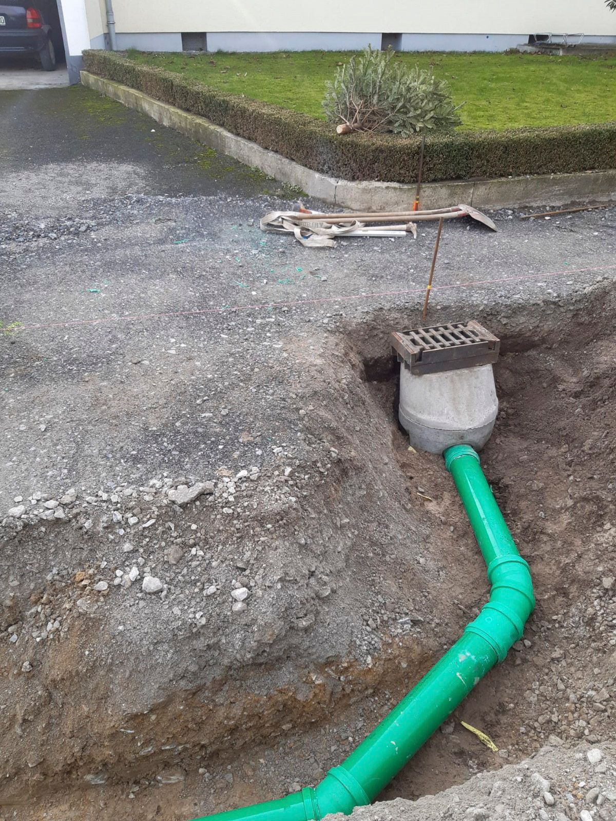 Aus einem Loch im Boden kommt ein grünes Rohr.