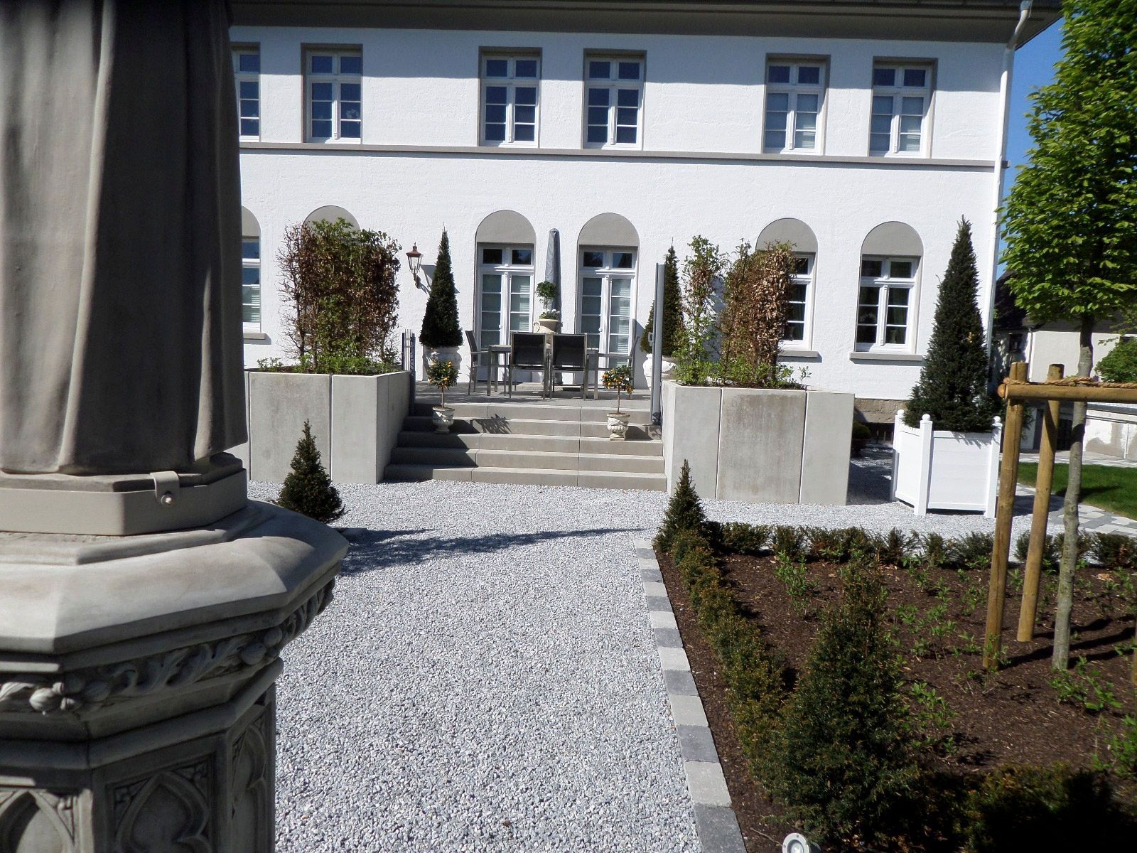 Ein großes weißes Gebäude mit einer Kiesauffahrt davor