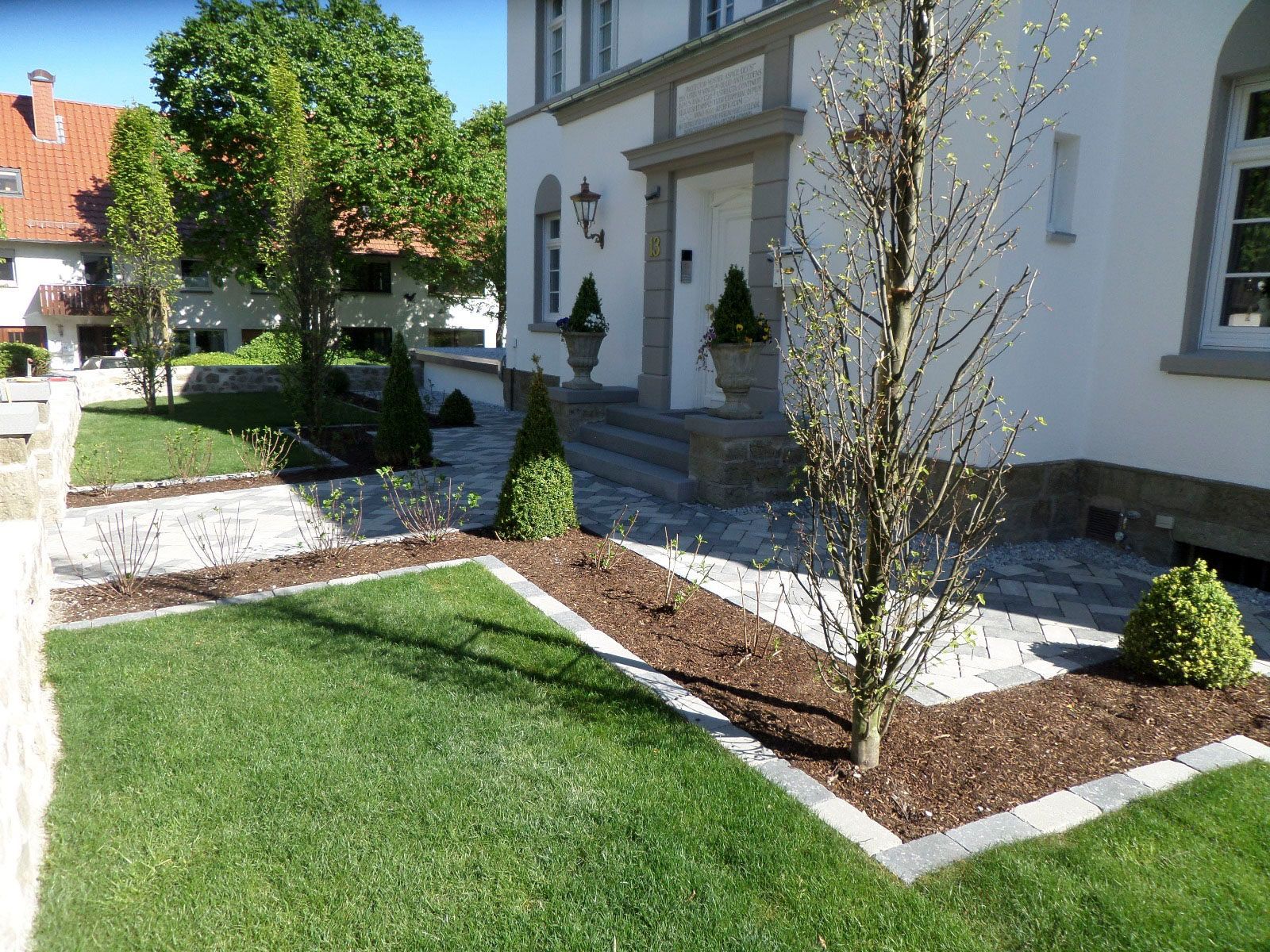 Ein weißes Haus mit einem üppigen grünen Rasen davor