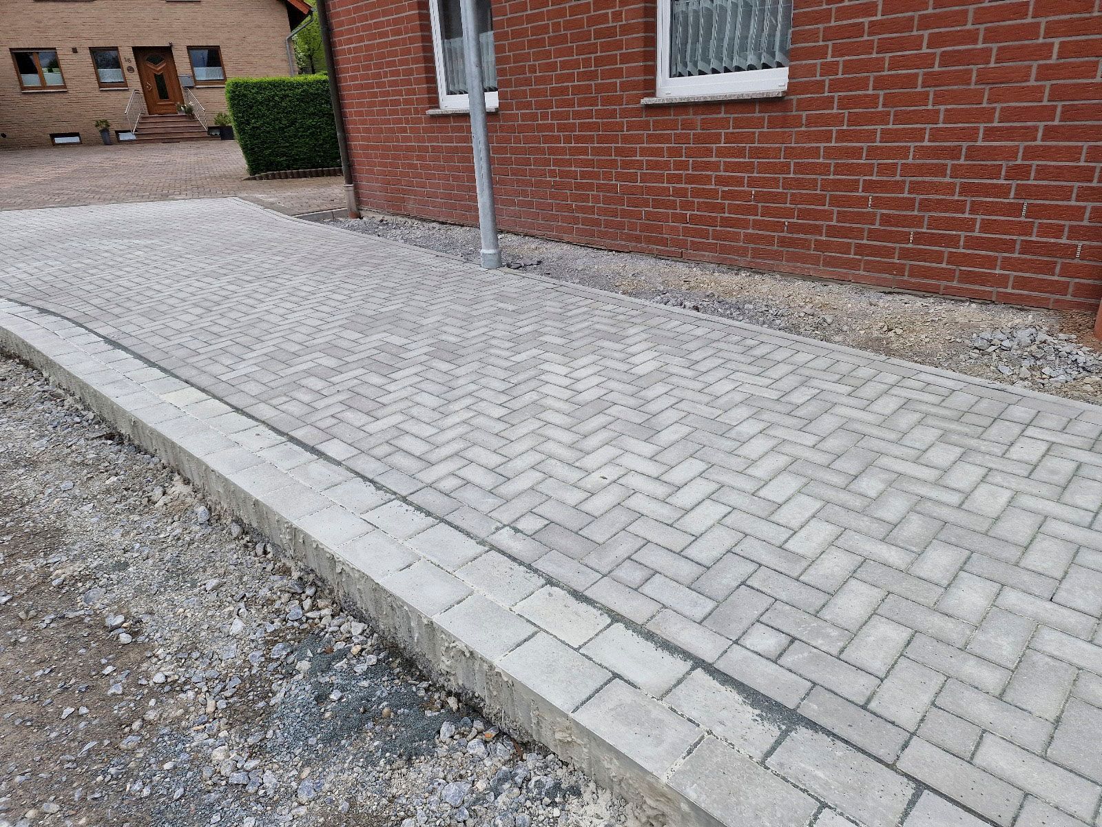 Vor einem Backsteingebäude wird ein Gehweg gebaut.