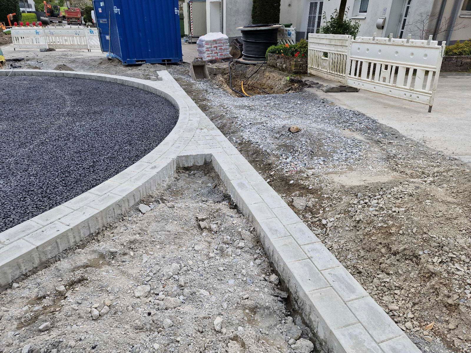 Eine Baustelle mit einem blauen Container im Hintergrund.