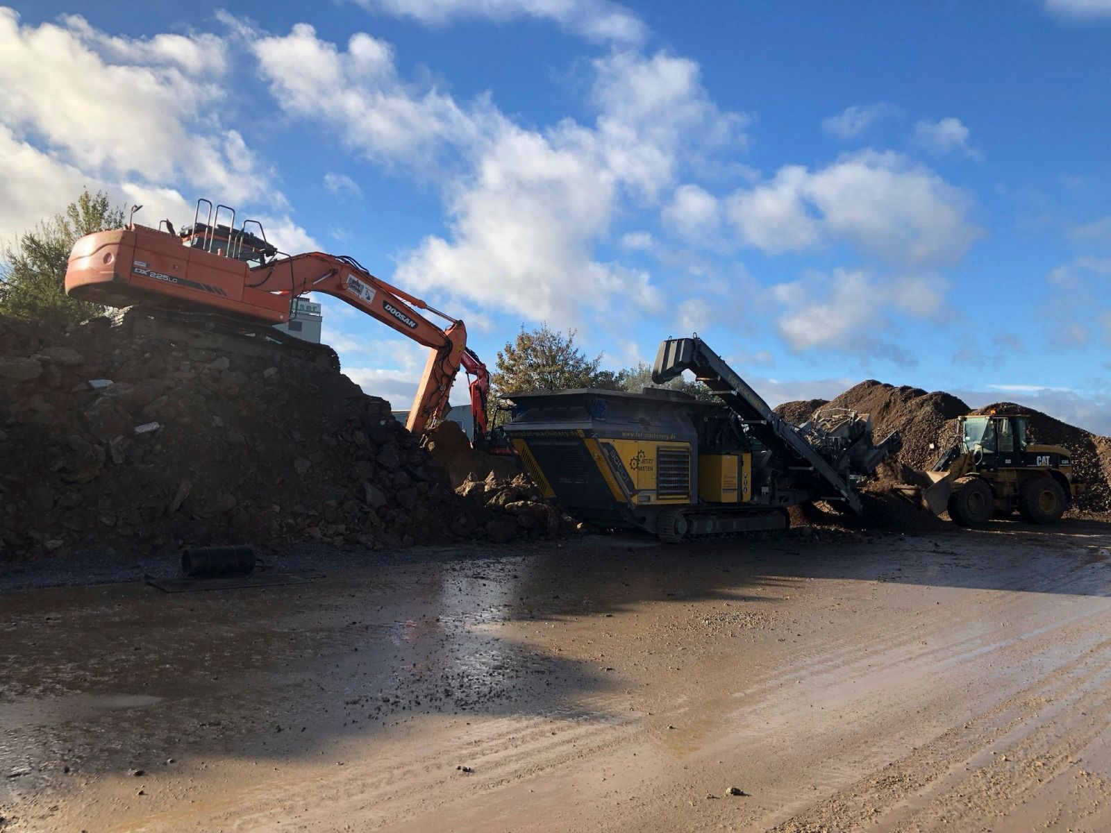 Ein großer Bagger steht auf einem Erdhaufen.