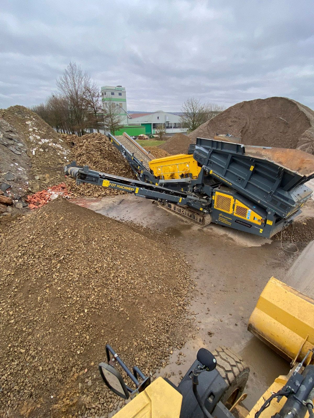 Eine Maschine steht auf einem Kieshaufen.