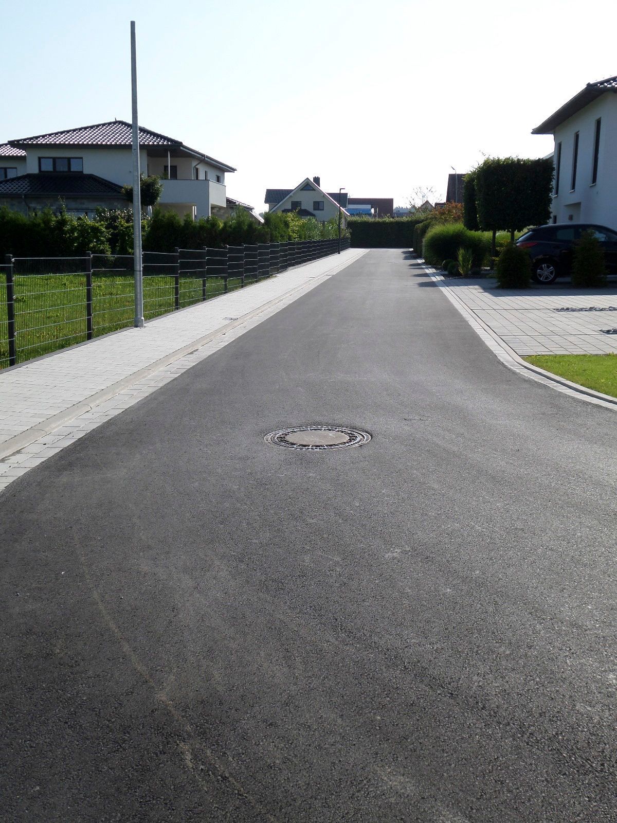 Eine Straße mit einem Gullydeckel in der Mitte