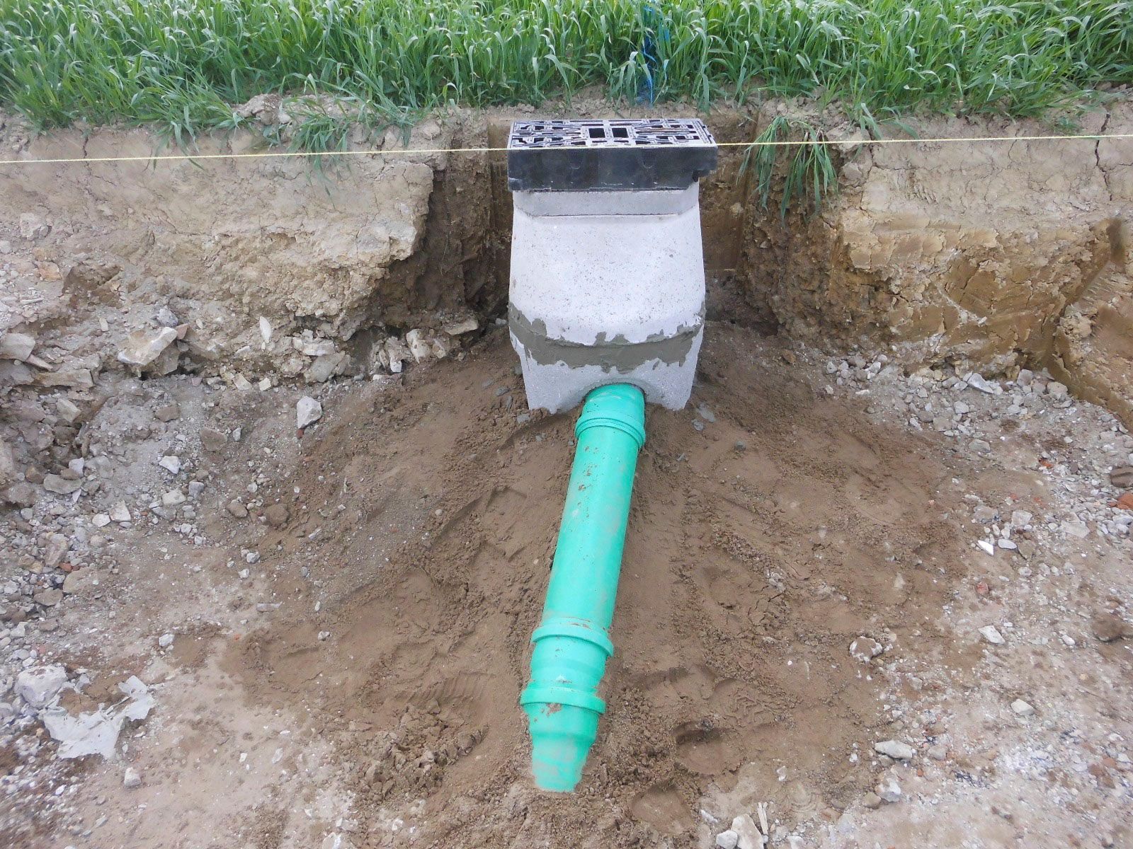 Ein grünes Rohr kommt aus einem Loch im Boden