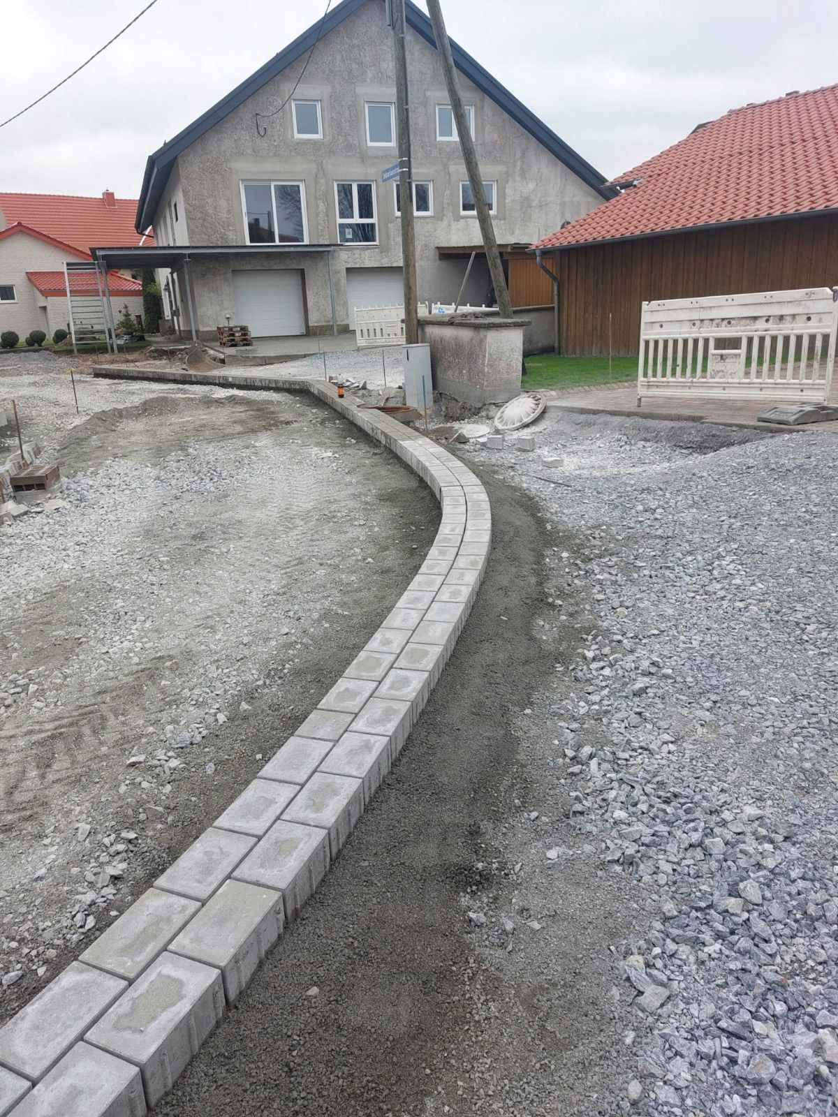 Vor einem Haus wird ein Ziegelweg gebaut.