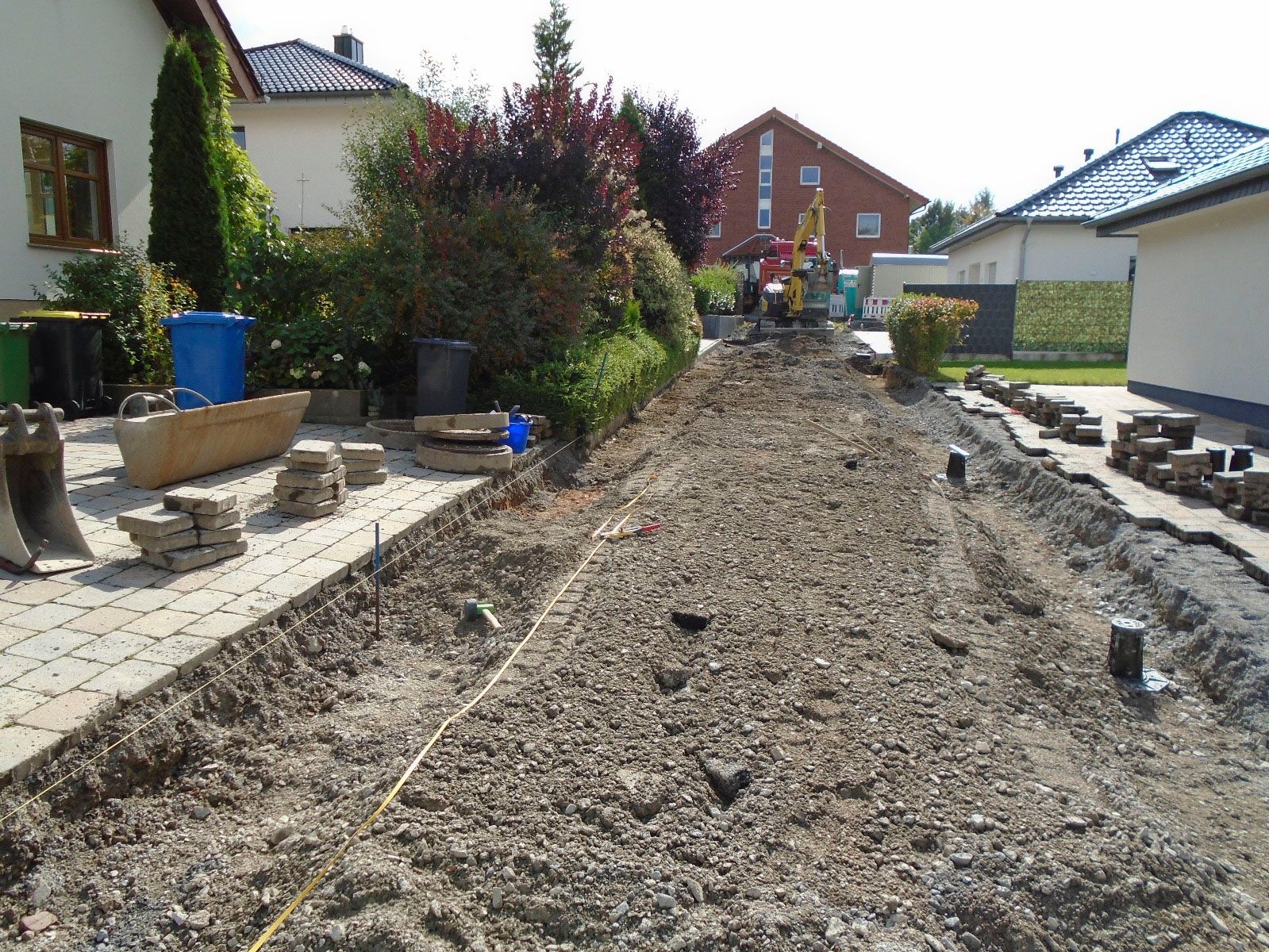 Vor einem Haus wird eine unbefestigte Straße gebaut