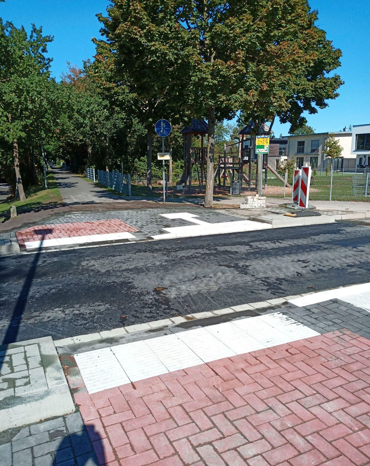 Am Straßenrand wird ein Zebrastreifen aufgemalt.