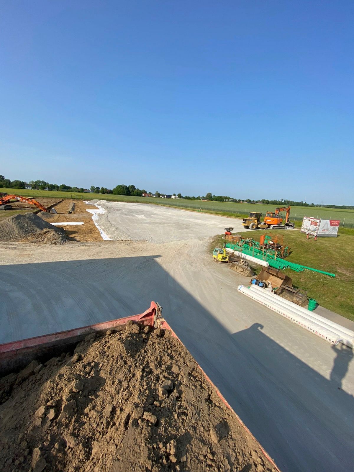 Am Straßenrand liegt ein großer Erdhaufen.