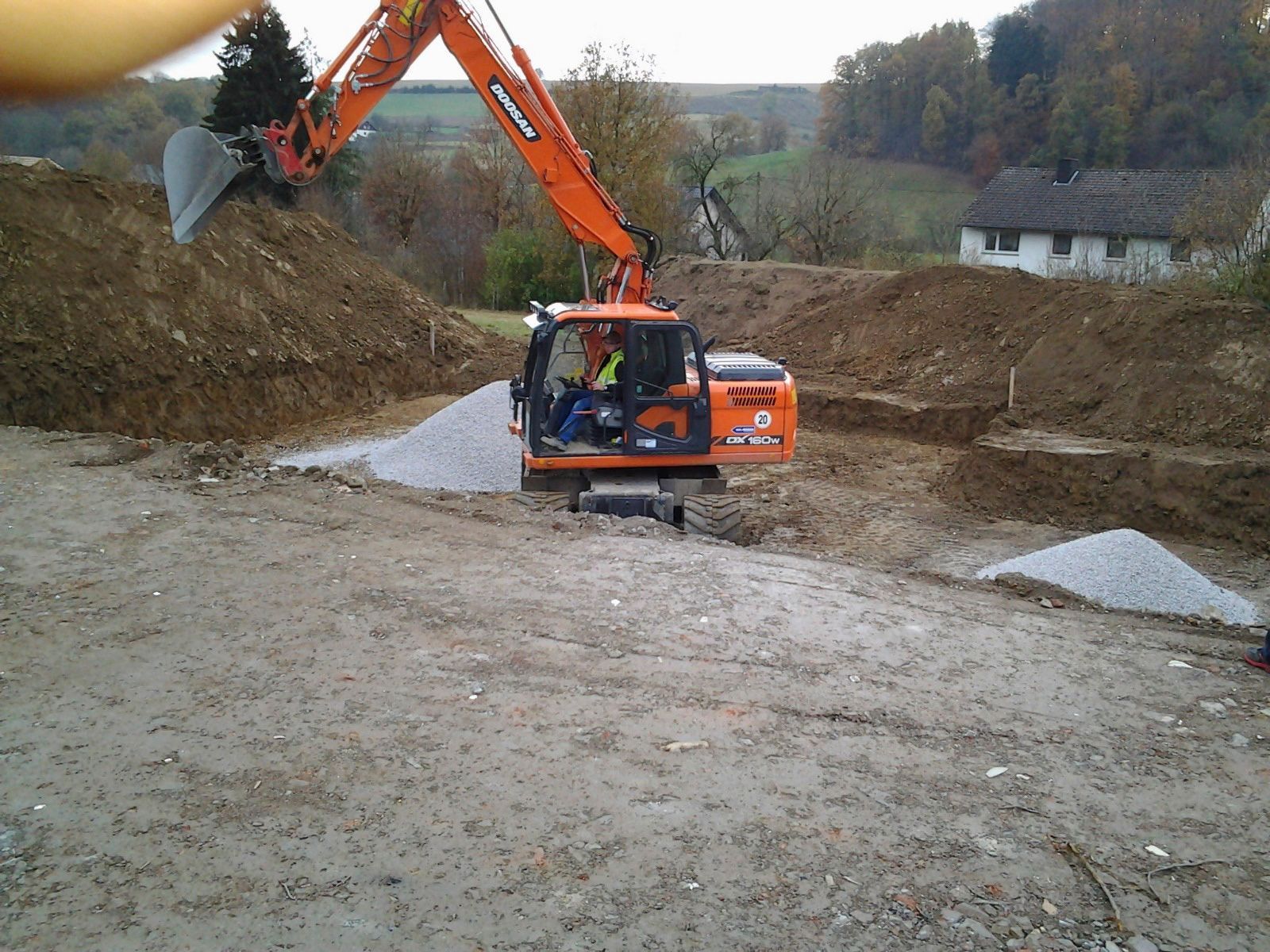 Ein Mann fährt einen Doosan-Bagger auf einem Feld
