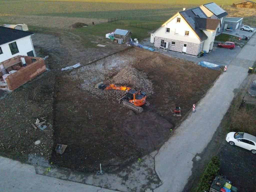 Eine Luftaufnahme einer Baustelle mit einem Haus im Hintergrund.