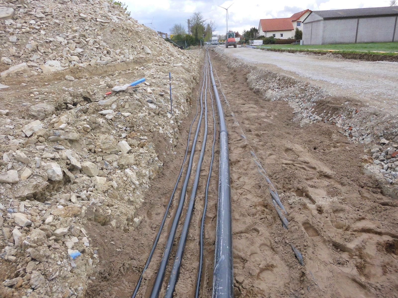 Ein Haufen Kabel liegt im Dreck am Straßenrand.