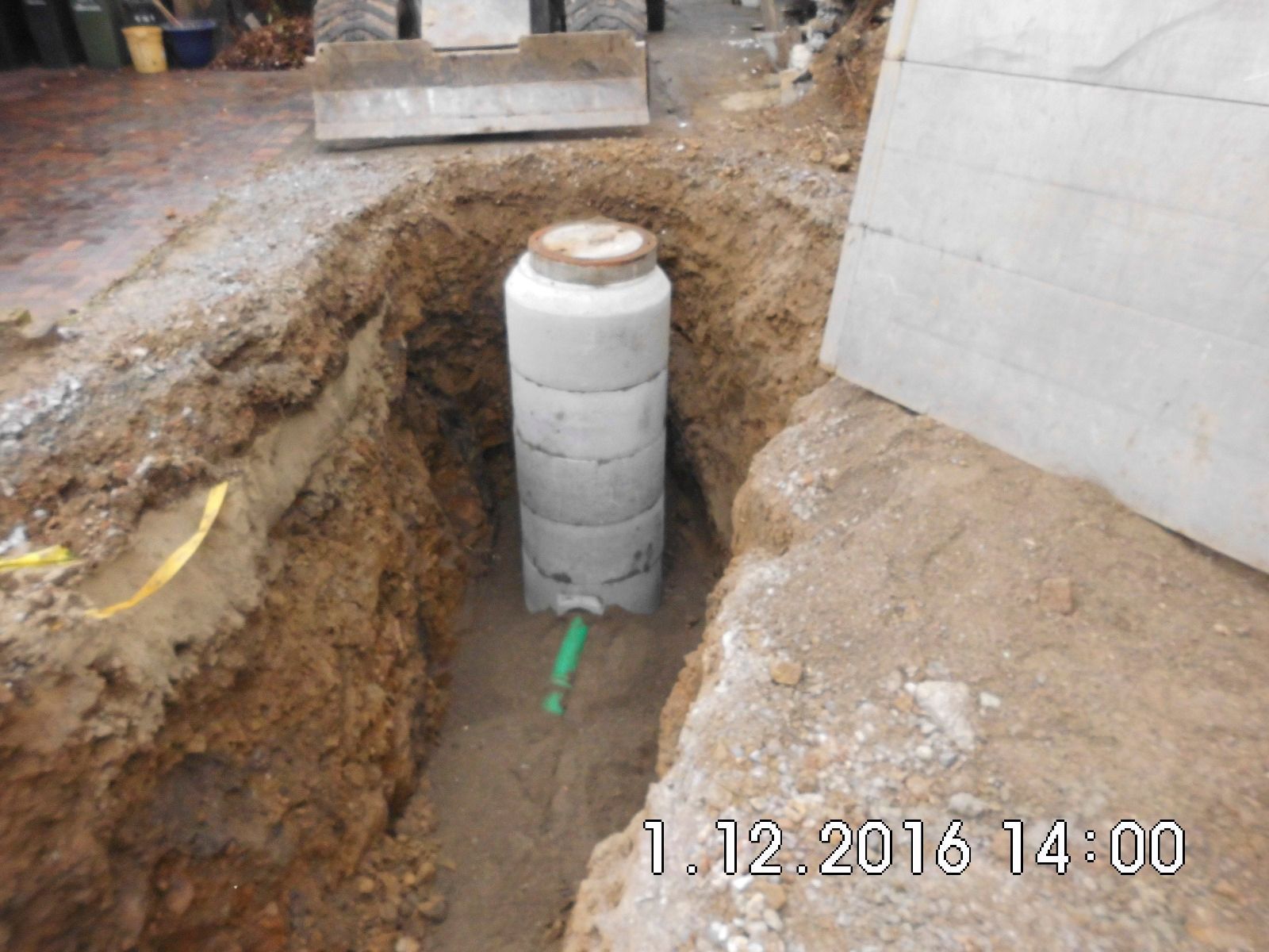 In einem Loch im Boden wird ein Betonrohr installiert.