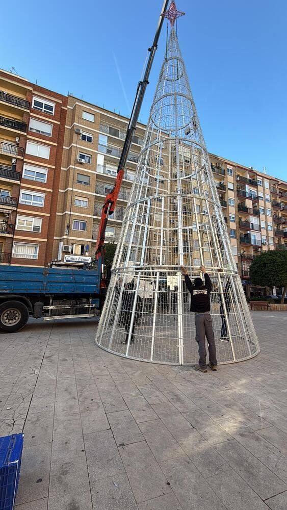 Camión TERENS azul con grúa, estacionado al aire libre contra un cielo nublado.