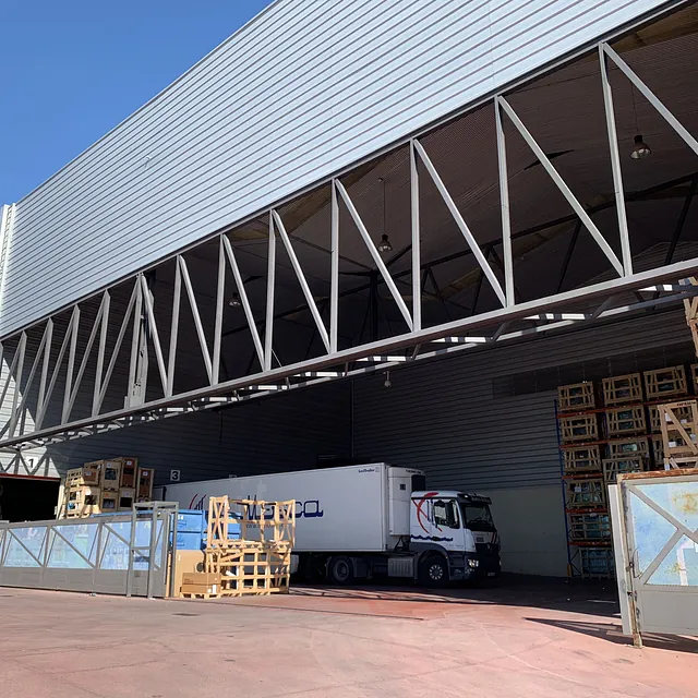 Un camión blanco está estacionado frente a un gran edificio.