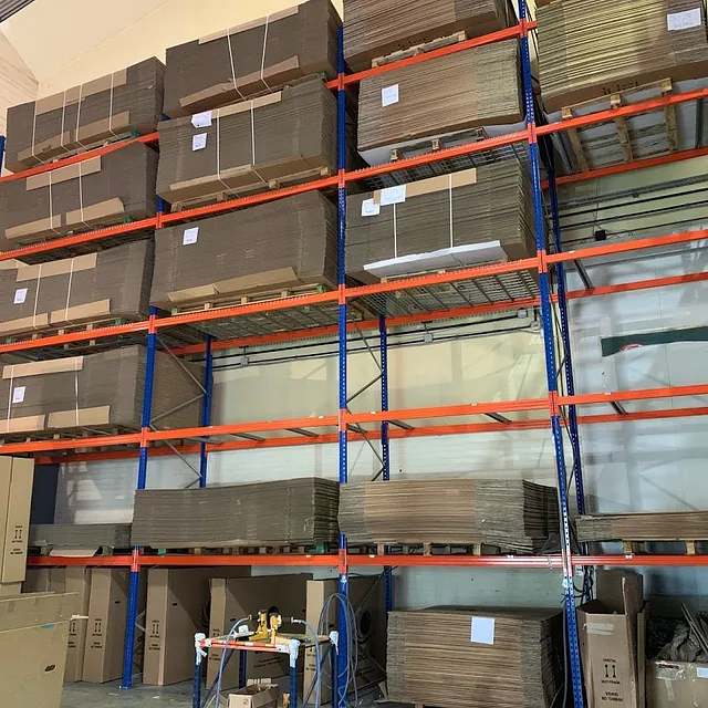 Las cajas de cartón se apilan en los estantes de un almacén