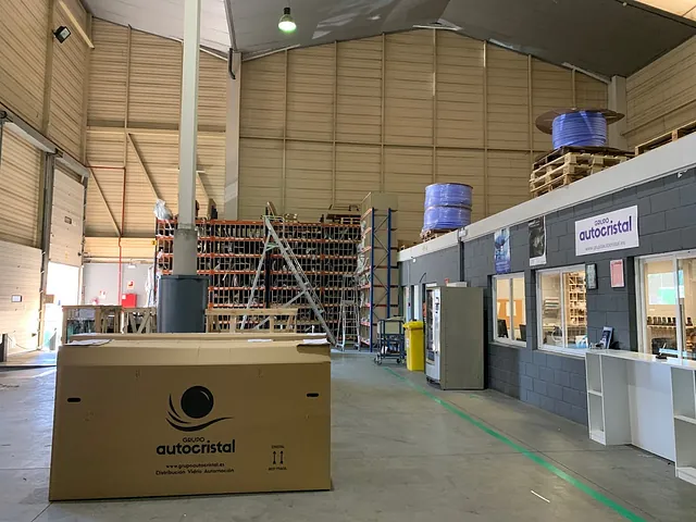 Una gran caja de cartón se encuentra en el medio de un gran almacén.