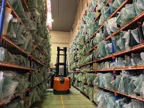Una carretilla elevadora circula por un almacén lleno de bolsas de plástico.