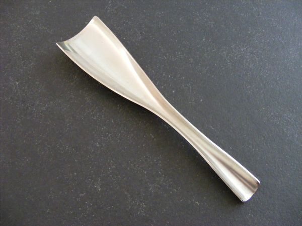 Ein silberner Löffel liegt auf einer schwarzen Oberfläche