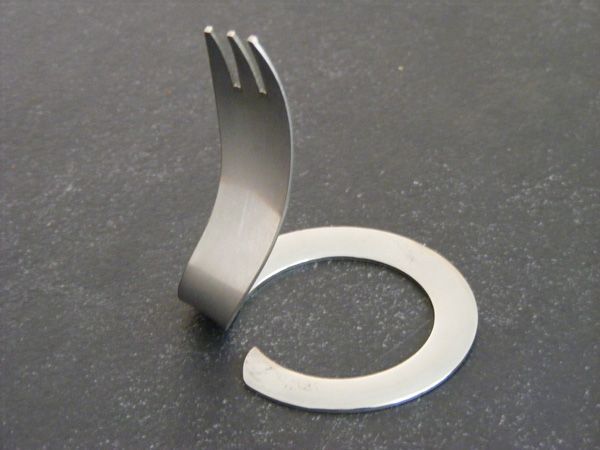 Eine Edelstahlgabel liegt auf einer schwarzen Oberfläche