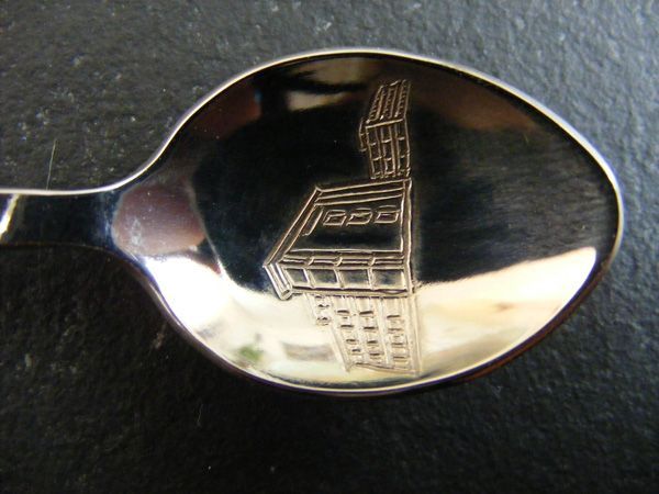 Ein silberner Löffel mit der Zeichnung eines Gebäudes darauf