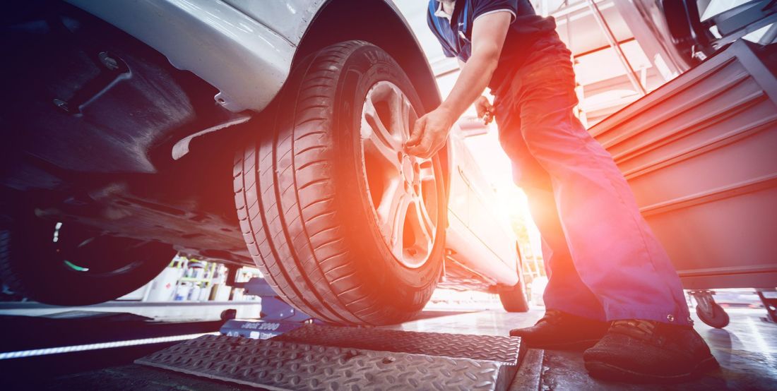 Un mécanicien s'occupe du pneu d'une voiture.