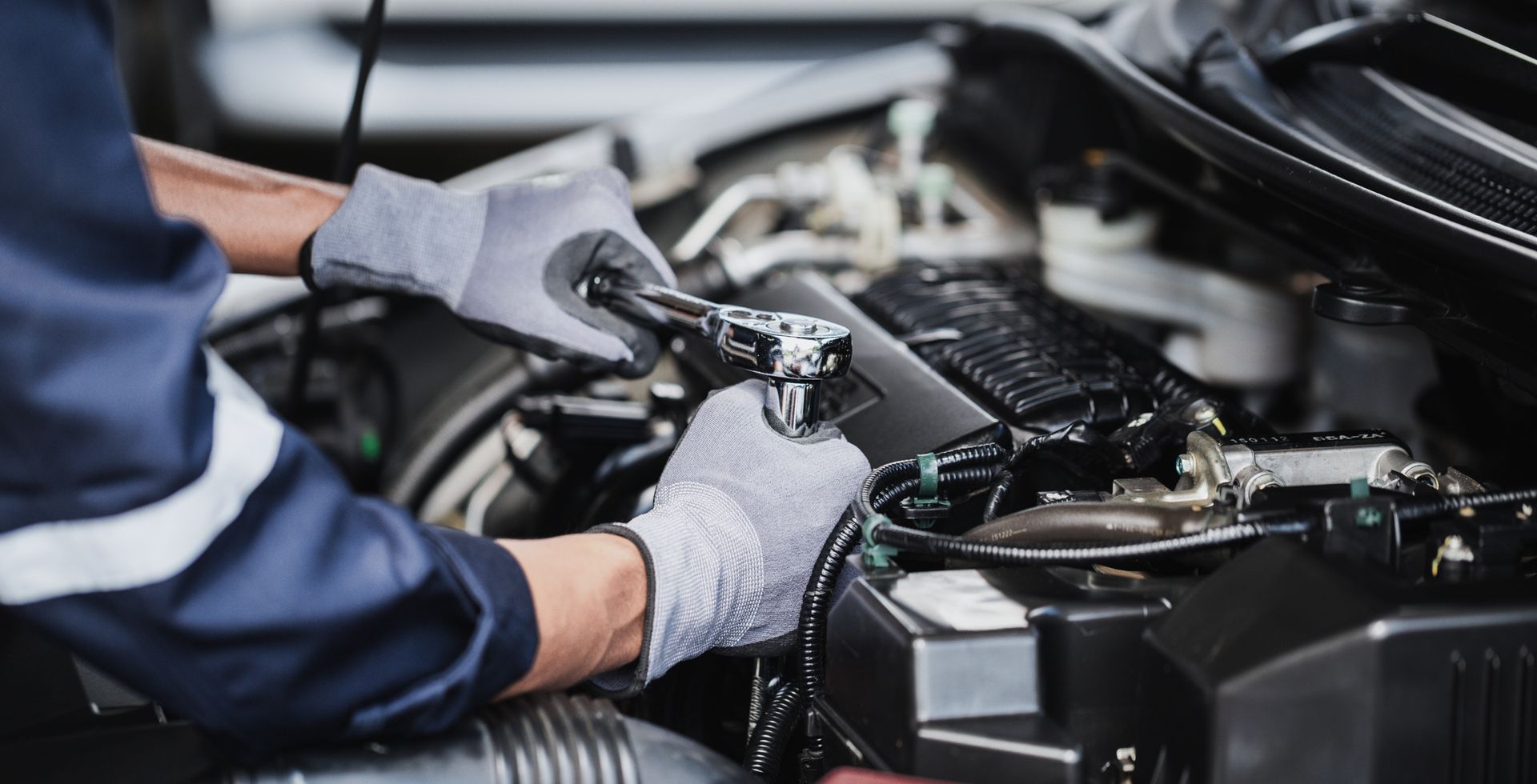 Un mécanicien portant des gants de travail gris.