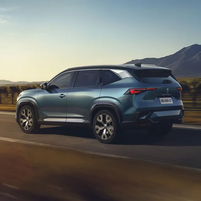 Un SUV Renault bleu métallisé circulant sur une route.