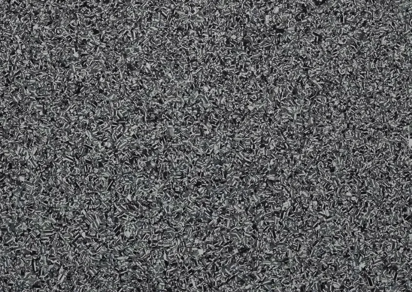 Eine strukturierte, einfarbige Oberfläche, bestehend aus kleinen, dicht gepackten grauen, schwarzen und weißen Fragmenten.