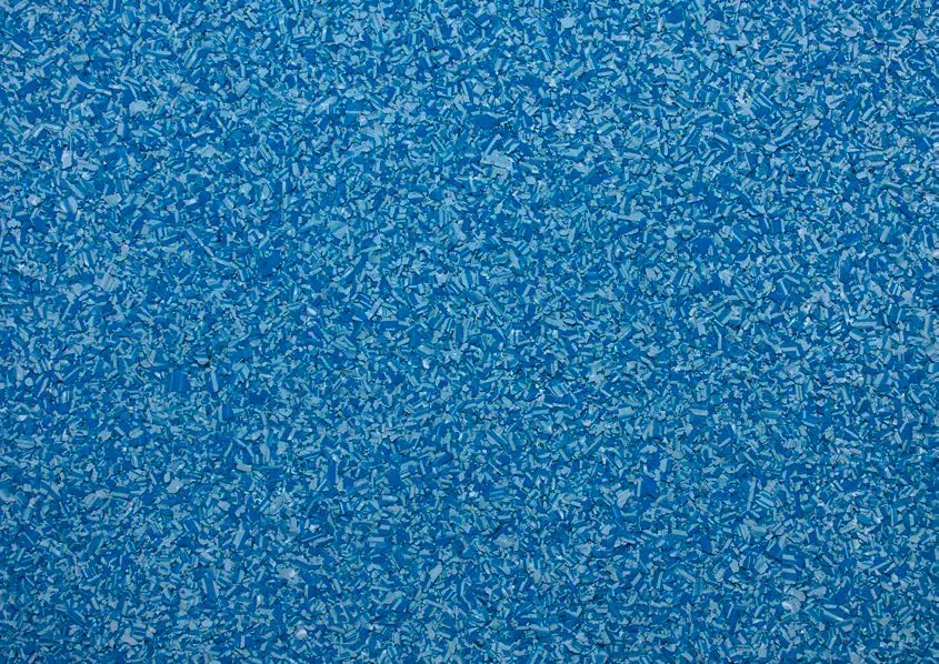 Eine strukturierte blaue Oberfläche mit weißen Sprenkeln, die an eine Schwimmbadfolie oder einen gemusterten Bodenbelag erinnert.